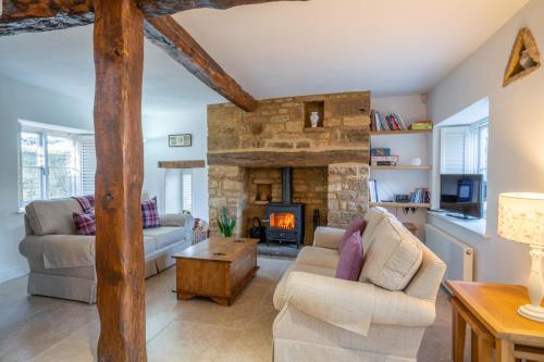 a large living room with a stone fireplace at Crofter's Barn in Chipping Norton