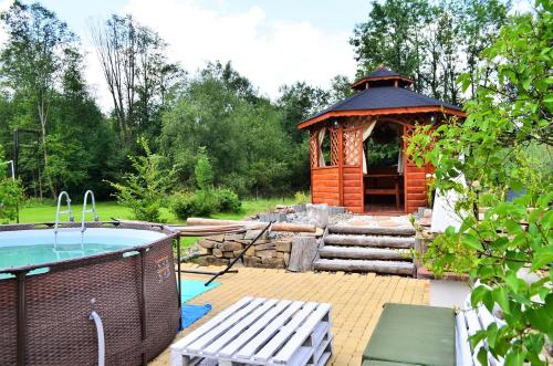 cenador de madera con bañera de hidromasaje en un patio en Chowańcówka, en Poronin