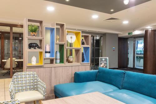 a living room with a blue couch in a store at Holiday Inn London - Regent's Park by IHG in London