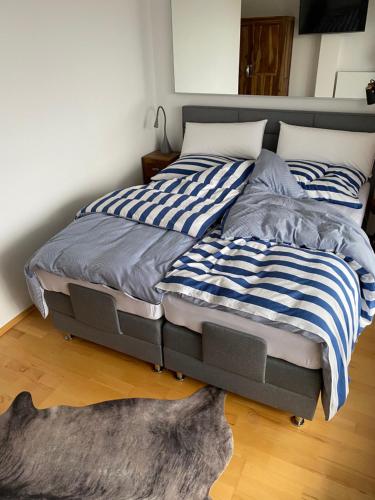 a bed with blue and white striped sheets on it at Inspiration Maisonette in Scharbeutz