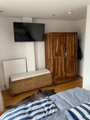 a bedroom with a bed and a cabinet and a tv at Inspiration Maisonette in Scharbeutz