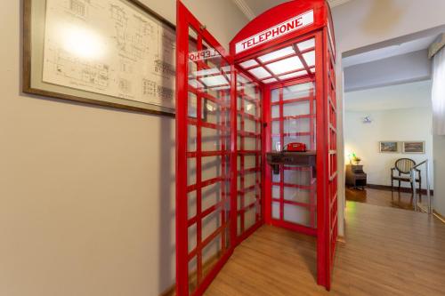 a red telephone booth in a room with a table at Hotel Solaris in São Lourenço