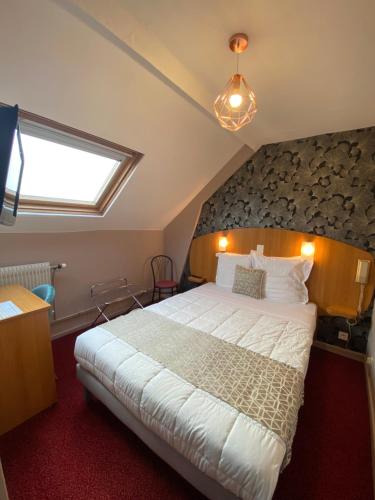 um quarto com uma cama grande e uma janela em Logis - Hôtel et Restaurant Le Sofhotel em Forges-les-Eaux