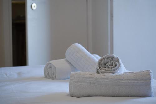 een stapel handdoeken bovenop een bed bij Elegant flat Marousi District in Athene