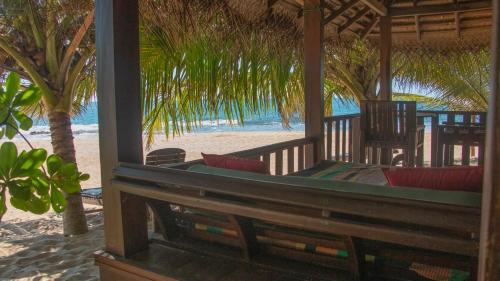 a pavilion on the beach with tables and chairs at Ganesh Garden Beach Cabanas in Tangalle
