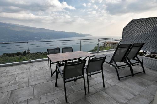 a table and chairs on a balcony with a view at La Dolce Vita Relais - Hotel Gallo in Tignale