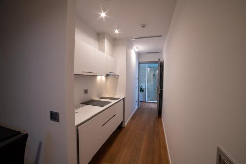 una cucina con armadietti bianchi e pavimenti in legno di Grandi 32 a Segrate
