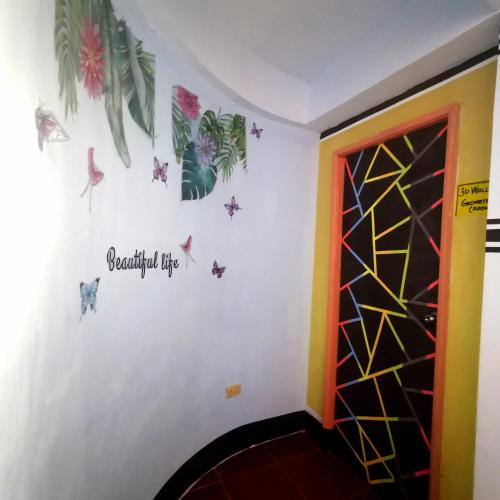 a room with a wall with butterflies and a door at Cabanatuan City PNY TRANSIENT INN 4 in Cabanatuan