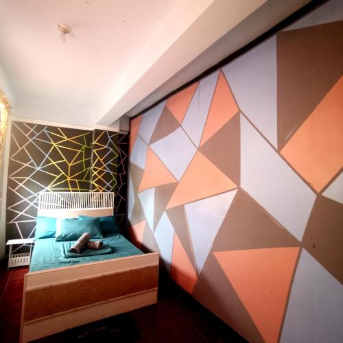 a room with a bed with a geometric wall at Cabanatuan City PNY TRANSIENT INN 4 in Cabanatuan
