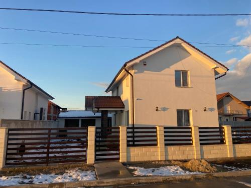 a house with a fence in front of it at Casa Andreea in Sînmartin