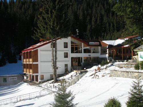 a large building with snow in front of it at Hotel Elitza in Pamporovo