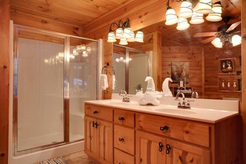 a bathroom with a shower and a sink and a mirror at Lucky Cub Cabin in Sevierville