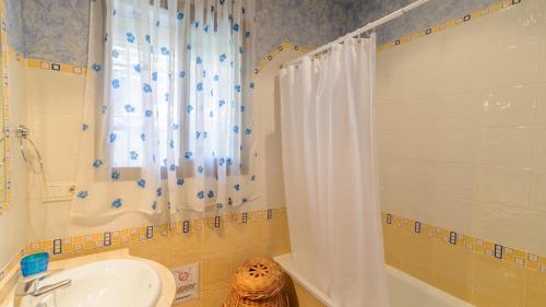 a bathroom with a shower curtain and a sink at Villa La Cola Nerja by Ruralidays in Nerja