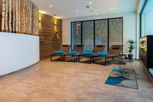 a lobby with a waiting room with blue chairs at Hotel Die Post Meerfeld in Meerfeld