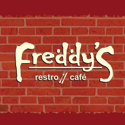 a red brick wall with a sign that readsheredys resko cafe at Fortune Plaza Hotel in Udupi