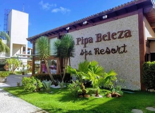 a building with a sign for a resort with palm trees at Pipa Beleza Spa Resort in Pipa