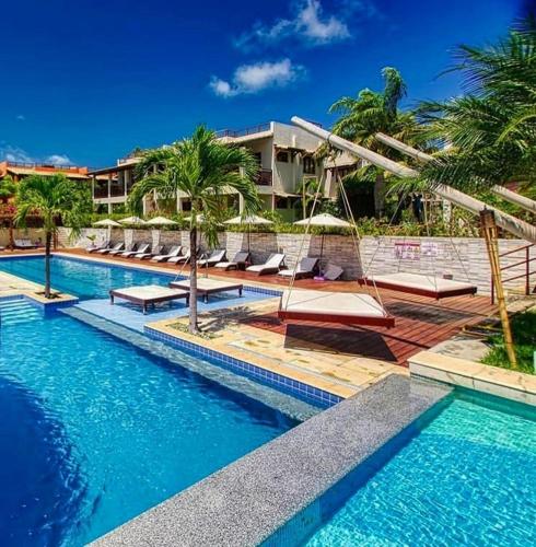 een zwembad met ligstoelen en een resort bij Pipa Beleza Spa Resort in Pipa