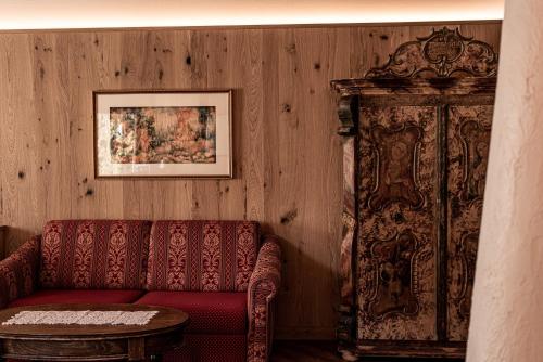 a living room with a red couch and a table at Aparthotel Kastel Seiser Alm in Castelrotto