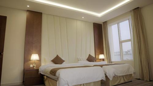a hotel room with two beds and a window at نزل خيال للشقق المخدومه in Jazan