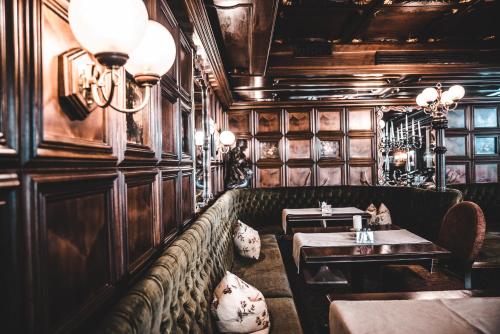 a restaurant with a bench and tables in a room at Cella Central Historic Boutique Hotel in Zell am See
