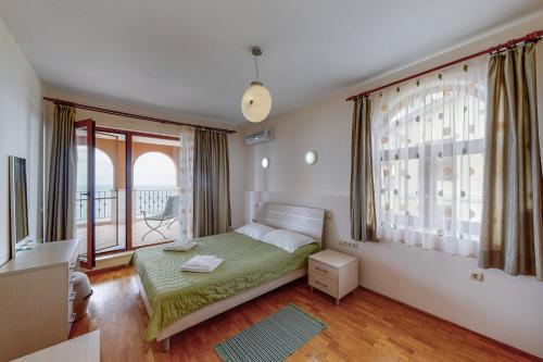 a bedroom with a bed and a large window at Lighthouse Luxe Estate Apart & Villas in Balchik