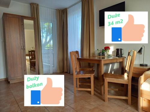 uma sala de jantar com uma mesa e cadeiras num quarto em Planeta Apartment Mielno em Mielno