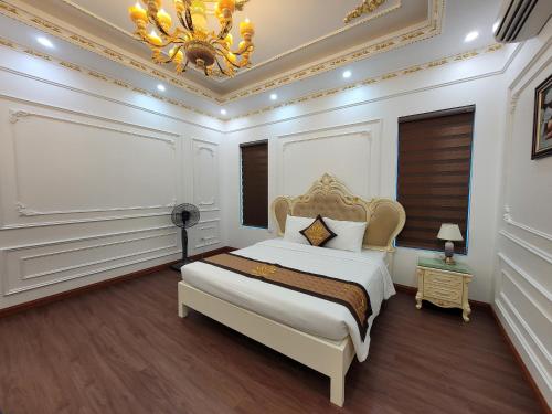 a bedroom with a king sized bed with a chandelier at Hoa Đông Aureum Hotel Hà Nam in Châu Cầu