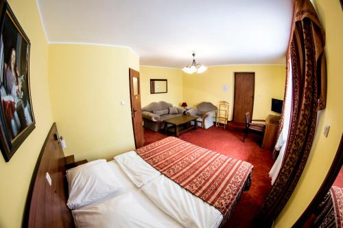 a bedroom with a bed and a living room at Dworek Dębówko in Bartoszyce