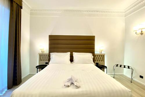 a bedroom with a large bed with a pair of shoes on it at BB Hotels Smarthotel Bailey's in Rome