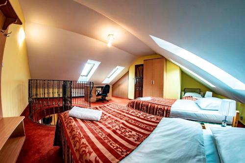 una camera d'albergo con due letti e una scala di Dworek Dębówko a Bartoszyce