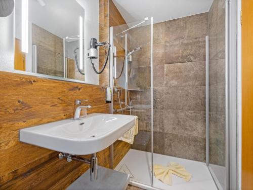 La salle de bains est pourvue d'un lavabo et d'une douche. dans l'établissement Landhotel Gabriele, à Unterwössen