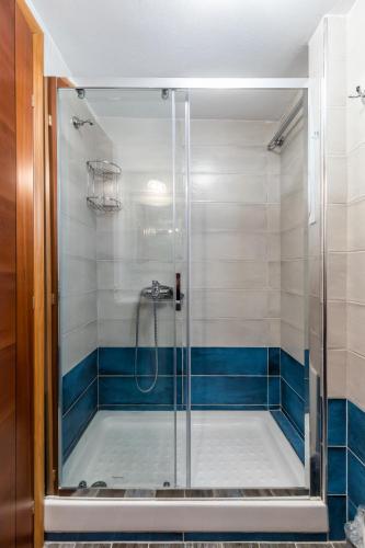 a shower in a bathroom with blue and white tiles at SUN NEST HOUSE in Skopelos Town