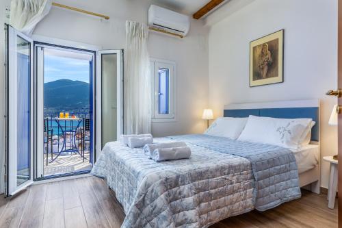 a bedroom with a bed and a balcony with a view at SUN NEST HOUSE in Skopelos Town