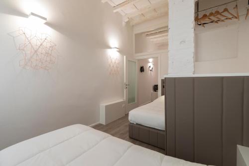 sypialnia z 2 łóżkami i ścianą z obrazem w obiekcie Cestello Suite by Mmega we Florencji