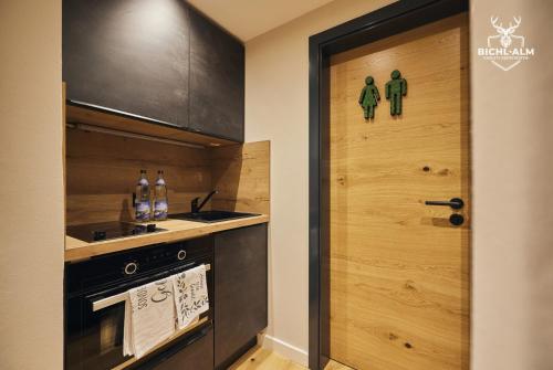 a kitchen with a door with two green men on it at Chalet Goldstück in Oberstaufen