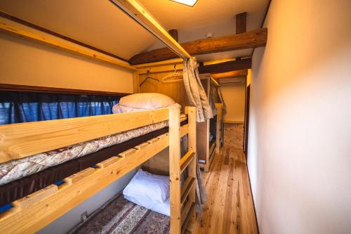 a couple of bunk beds in a room at 古民家ゲストハウスひまわり in Isa