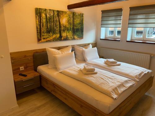 a bedroom with a bed with two towels on it at Hotel Garni und Gaststätte Zum Holzfäller in Schierke