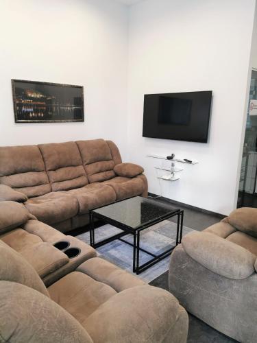 a living room with two couches and a flat screen tv at FEWO am Neuen Dom in Linz