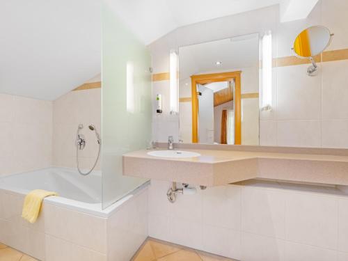 a white bathroom with a sink and a mirror at Landhotel Gabriele in Unterwössen