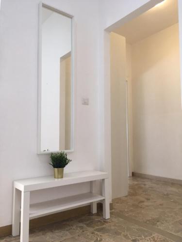 a white table with a mirror and a potted plant on it at a tre passi dal centro in Forlì