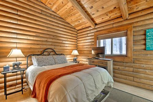a log cabin bedroom with a bed and a window at 11 Mi to Rainbow Lake Family Home with Large Yard in Indian Pine