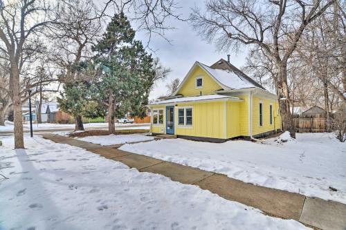 a yellow house in the snow with a driveway at Contemporary Longmont Hideaway in Old Town! in Longmont