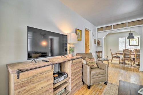 a living room with a flat screen tv and a chair at Beautiful Thermopolis Home with Private Yard and Grill in Thermopolis