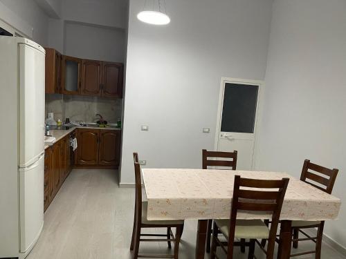 a kitchen with a table with chairs and a refrigerator at Apartament Gjergji in Sarandë