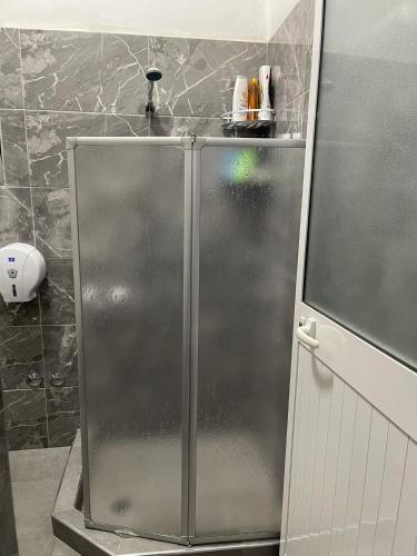 a stainless steel refrigerator in a bathroom with at Apartament Gjergji in Sarandë