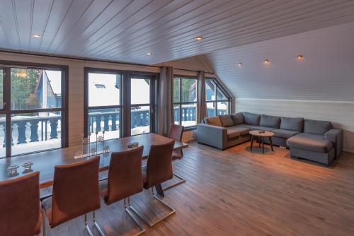 a room with a couch and a table and chairs at Bakkebyvegen 22B in Trysil