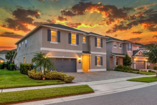 a house with a sunset in the background at Spacious 8 BDR Family Home with Arcades and Free Pool Heat in Orlando