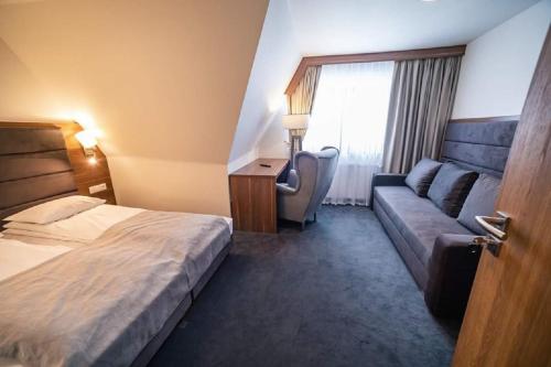 a hotel room with a bed and a couch at GORSKI RESORT Lux Apartments Jacuzzi & Sauna in Poronin