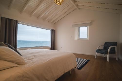 a bedroom with a large bed and a large window at Villa Mar - Maia in Maia