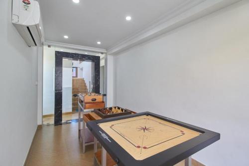 a room with a table with a clock on the wall at Hotel Mart View in Cochin